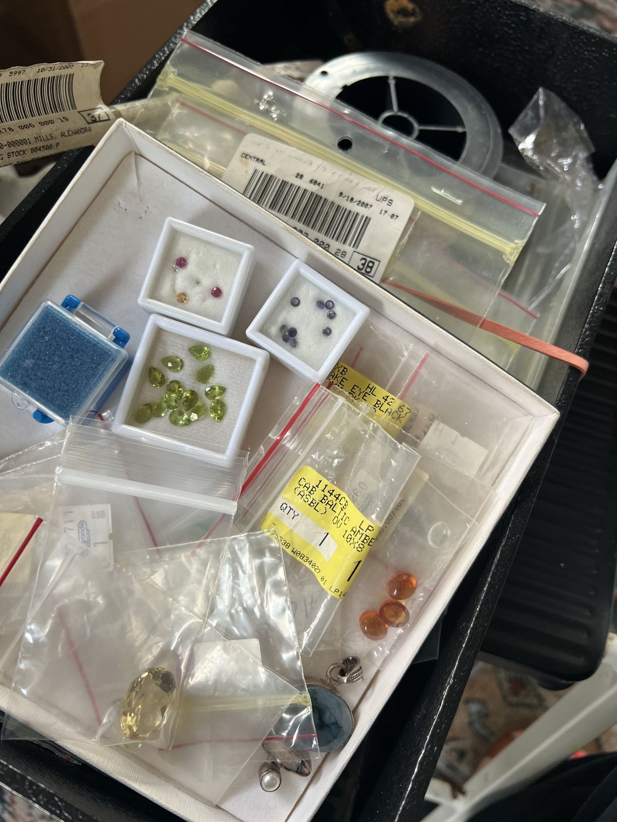 Faceted stones stored in small gem boxes and bags